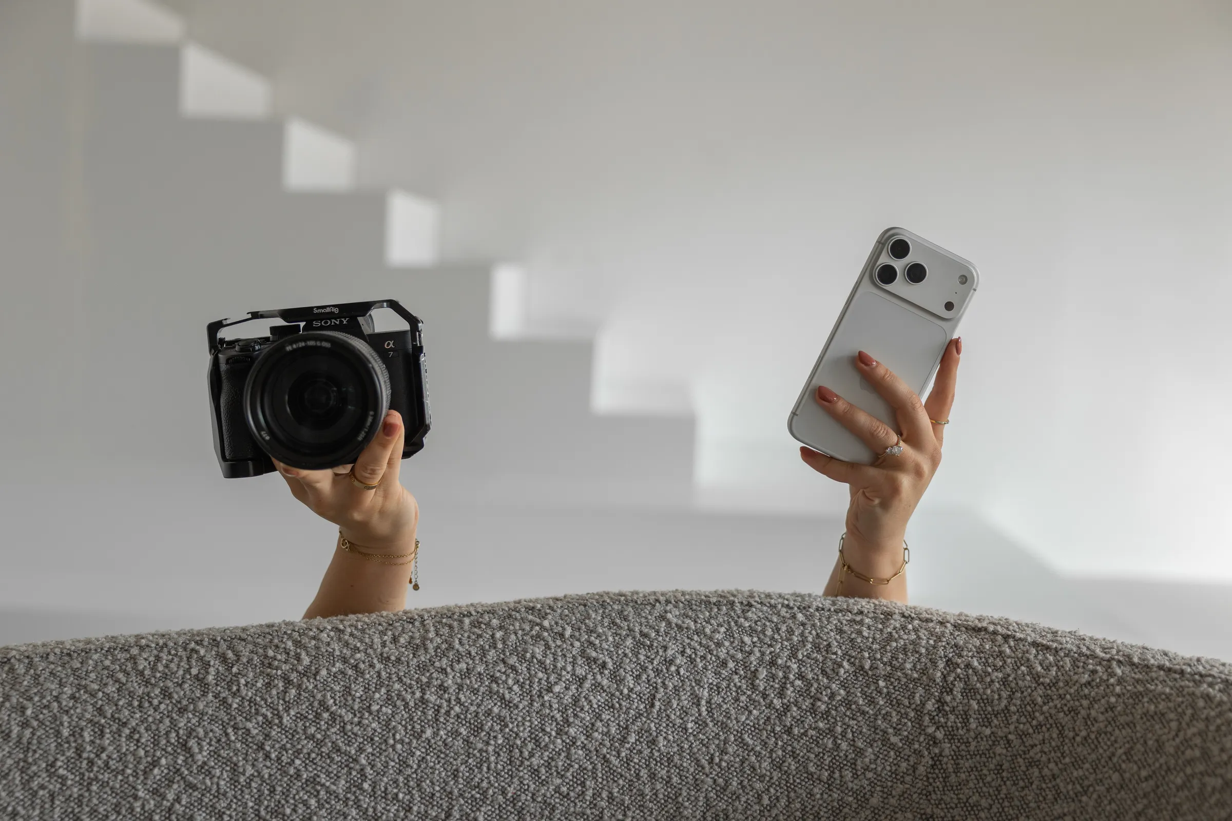Vienna houdt haar camera en telefoon omhoog achter de bank